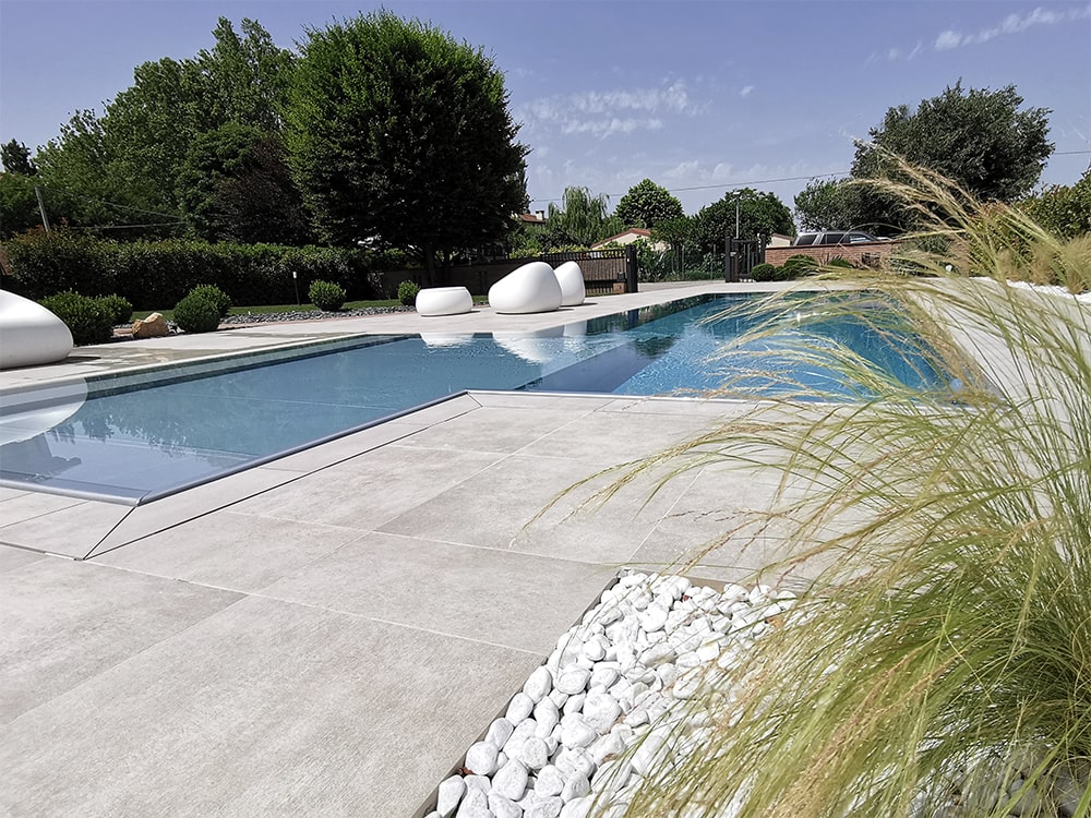 Giardino realizzato da Junior Garden con piscina, graminacee e alberi